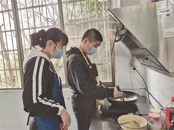 烹饪课上，学生在生活老师的指点下煎鸡蛋饼.jpg